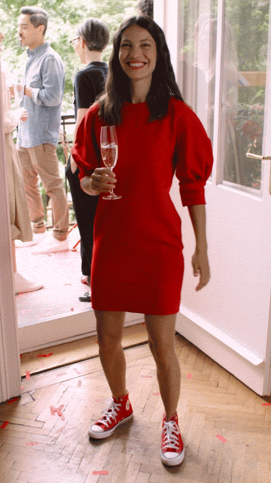 Frau im roten Kleid mit Sektglas